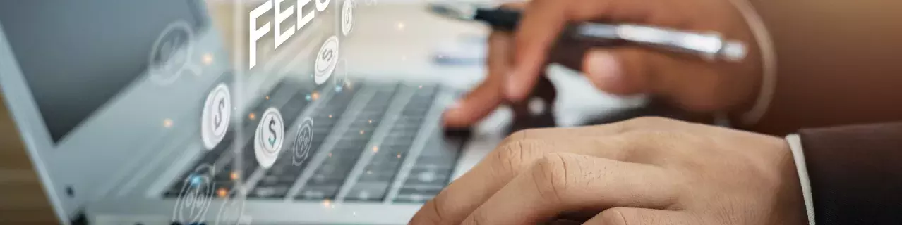 A person working at a laptop that says "fees."