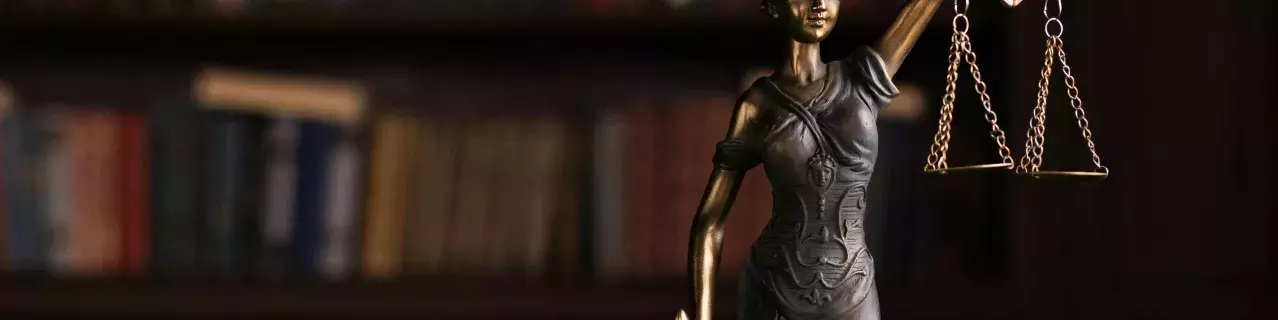 A small sculpture of lady justice holding scales and a sword