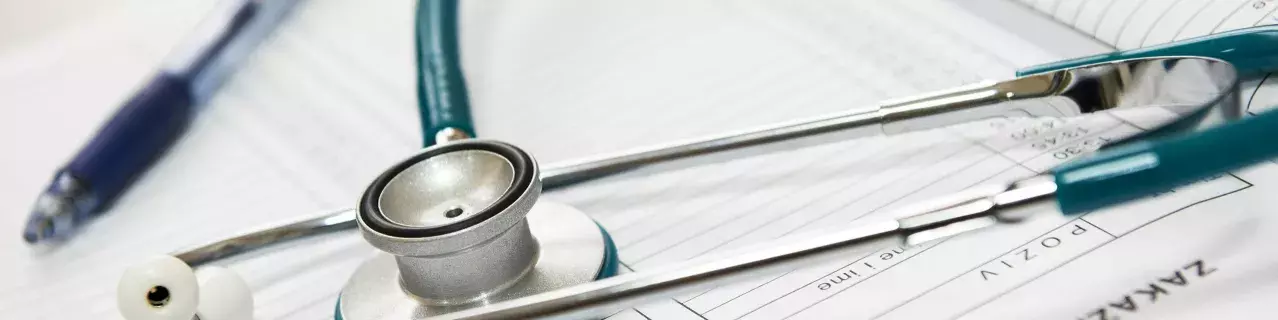 A photo of a stethoscope on top of medical paperwork