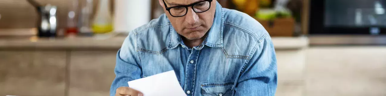 A person frowning while looking at paperwork