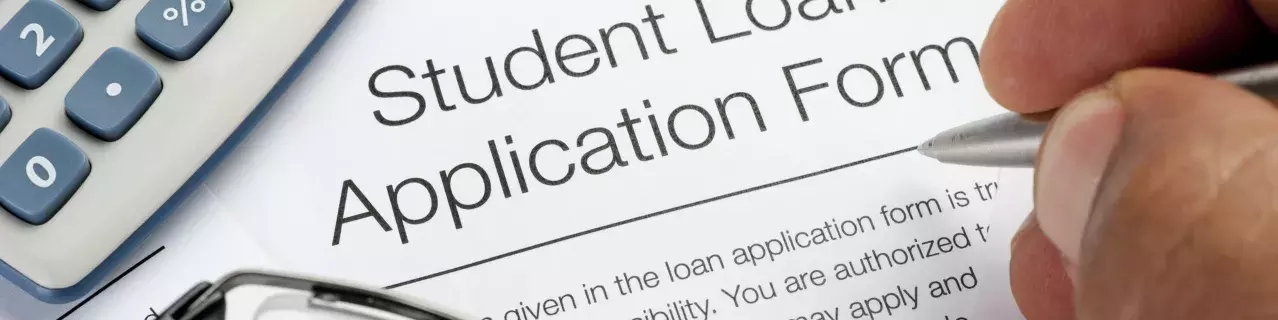 A person filling out a student loan application form