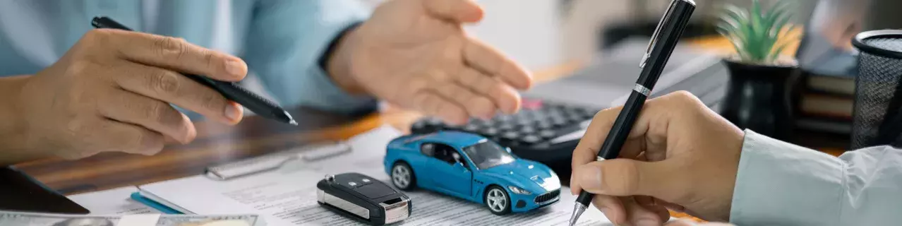 A photo of a person signing a car loan