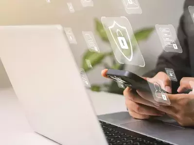 A person with a laptop and lock icons floating above it.
