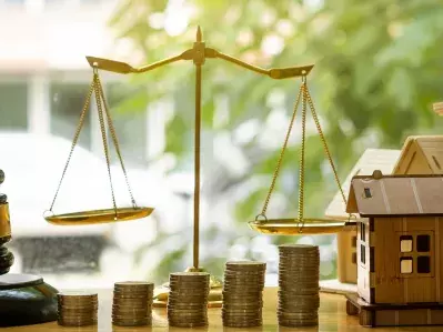 A still art photo of a gavel, house, and scales of justice