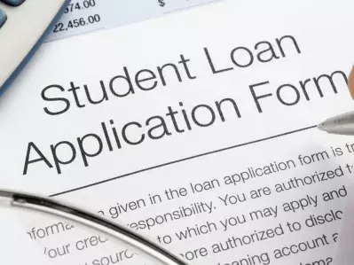 A person filling out a student loan application form