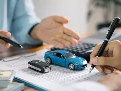 A photo of a person signing a car loan