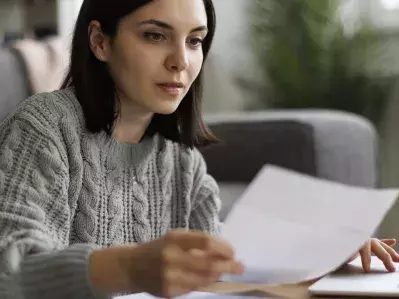 A person looking at a bill inquisitively