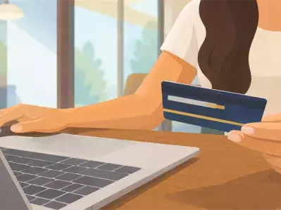 Woman holding credit card while using laptop