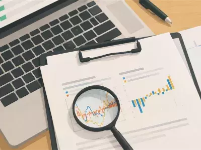 Magnifying glass over chart on laptop