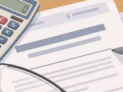 Calculator with loan papers and glasses on desk