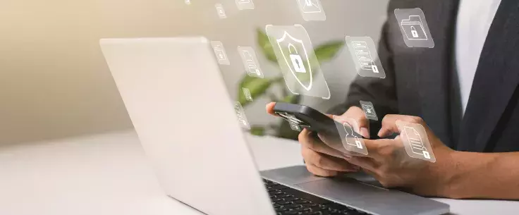 A person with a laptop and lock icons floating above it.